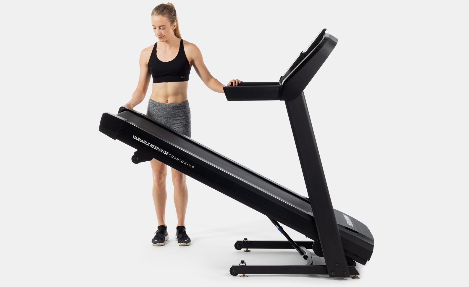 Woman unfolding treadmill